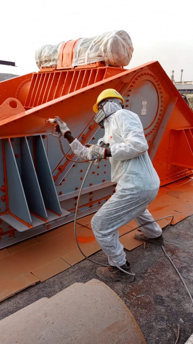 Peintre MSE appliquant un revêtement anticorrosion au pistolet sur un crible vibrant