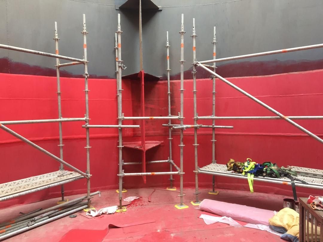 Intérieur d'une cuve CIL revêtu d'une peinture anticorrosion rouge, avec échafaudage